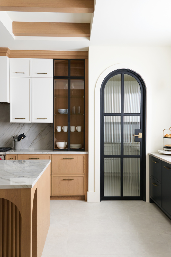 Transitional kitchen cabinetry with black arched pantry door by DesignLab in a Fairfax County custom home