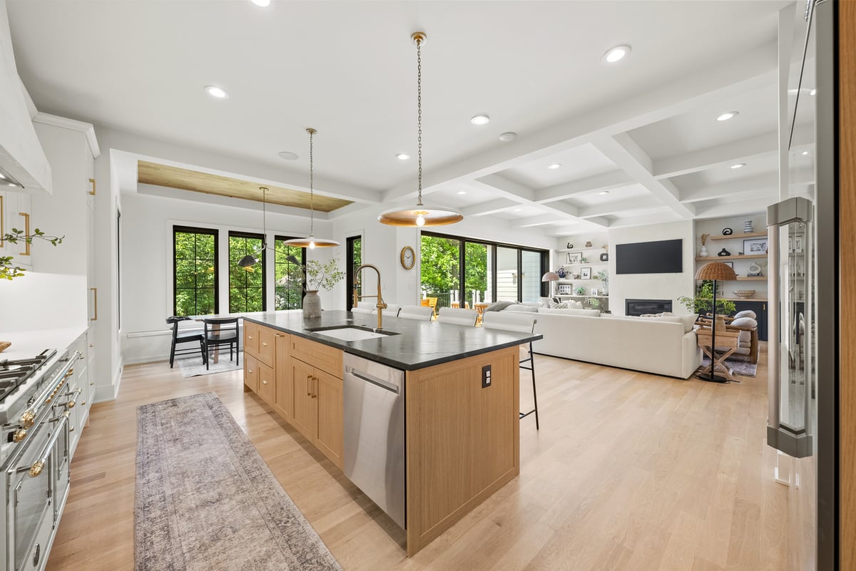 Modern open concept kitchen and living room in Vienna, VA, with large windows and light wood floors