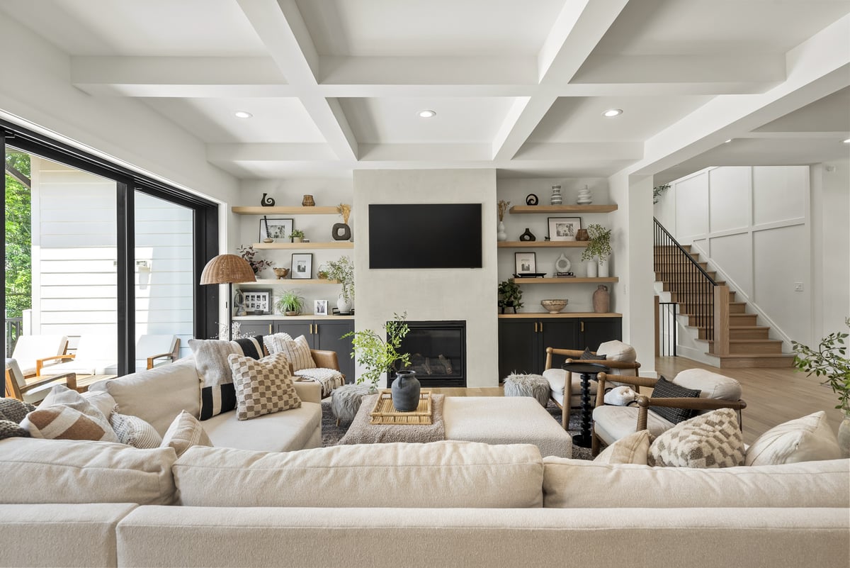 Remodeled living room with large windows and a fireplace