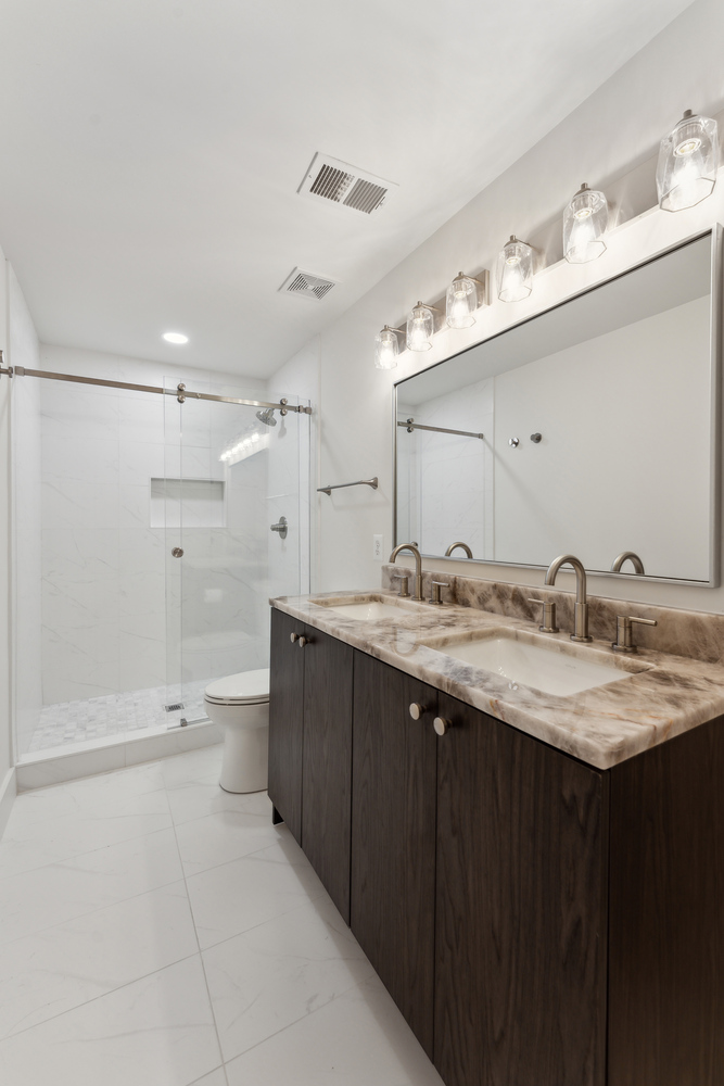 Bathroom renovation with dual sinks and marble counter by DesignLab in Metro Washington