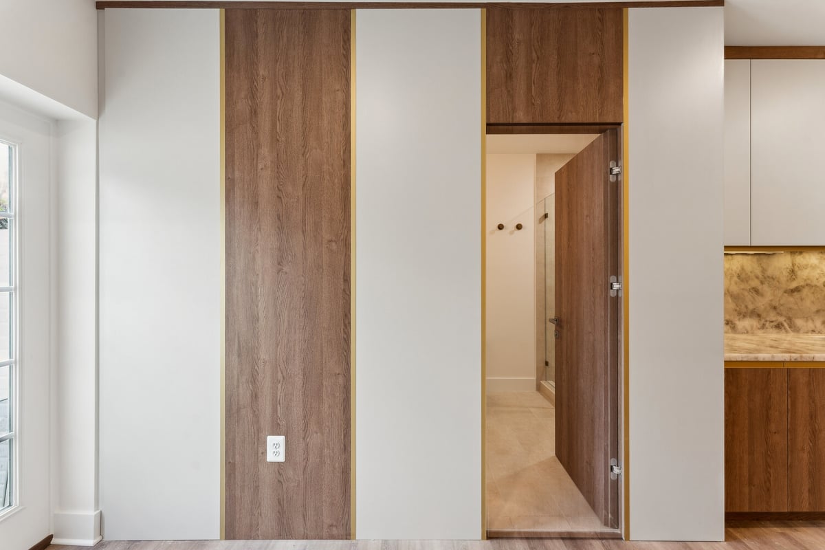 Hidden door detail with wood paneling in modern Metro Washington remodel by DesignLab