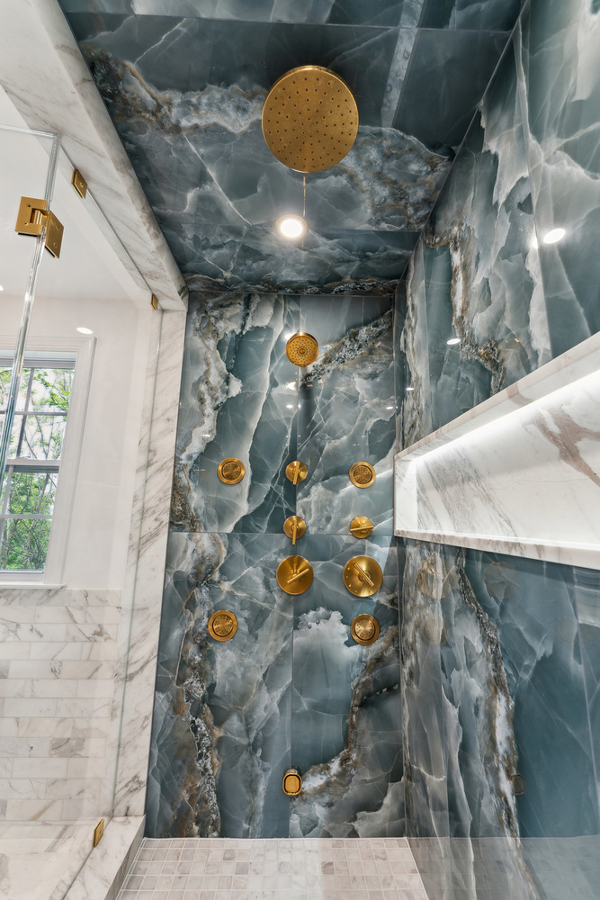 Luxury shower with full marble surround and rainfall fixtures by DesignLab in Metro Washington