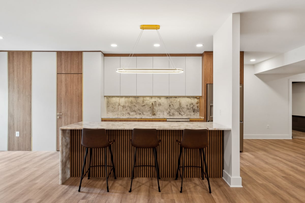 Modern kitchen remodel with marble island and wood accents by DesignLab in Metro Washington