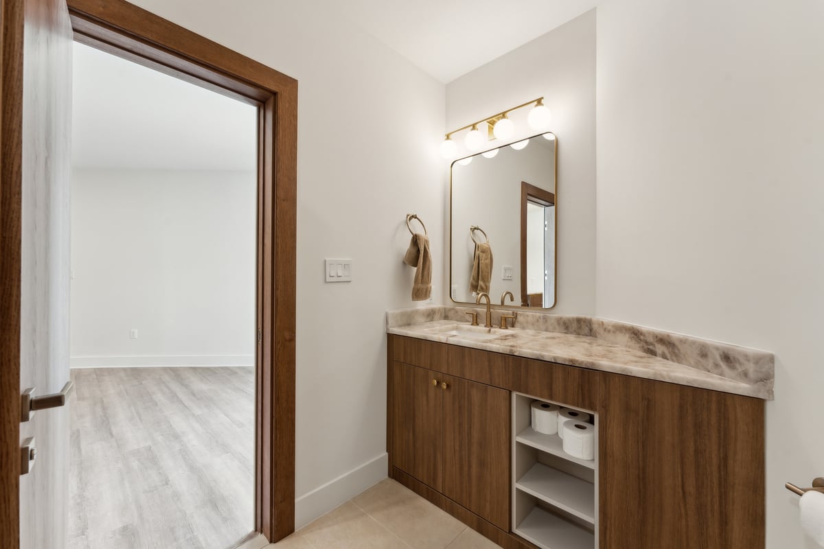 Small bathroom remodel with wood vanity and gold accents by DesignLab in Metro Washington