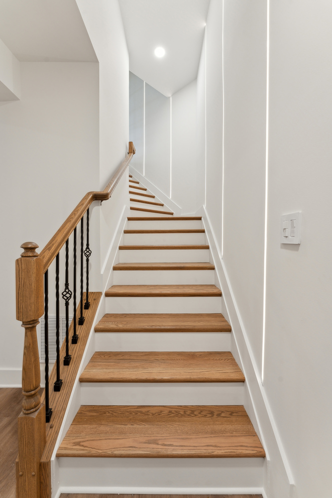 Stylish staircase renovation with wood treads and modern railing by DesignLab in Metro Washington