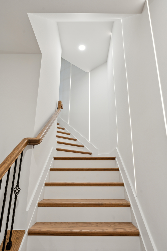 Upward view of modern wood staircase design by DesignLab in Metro Washington