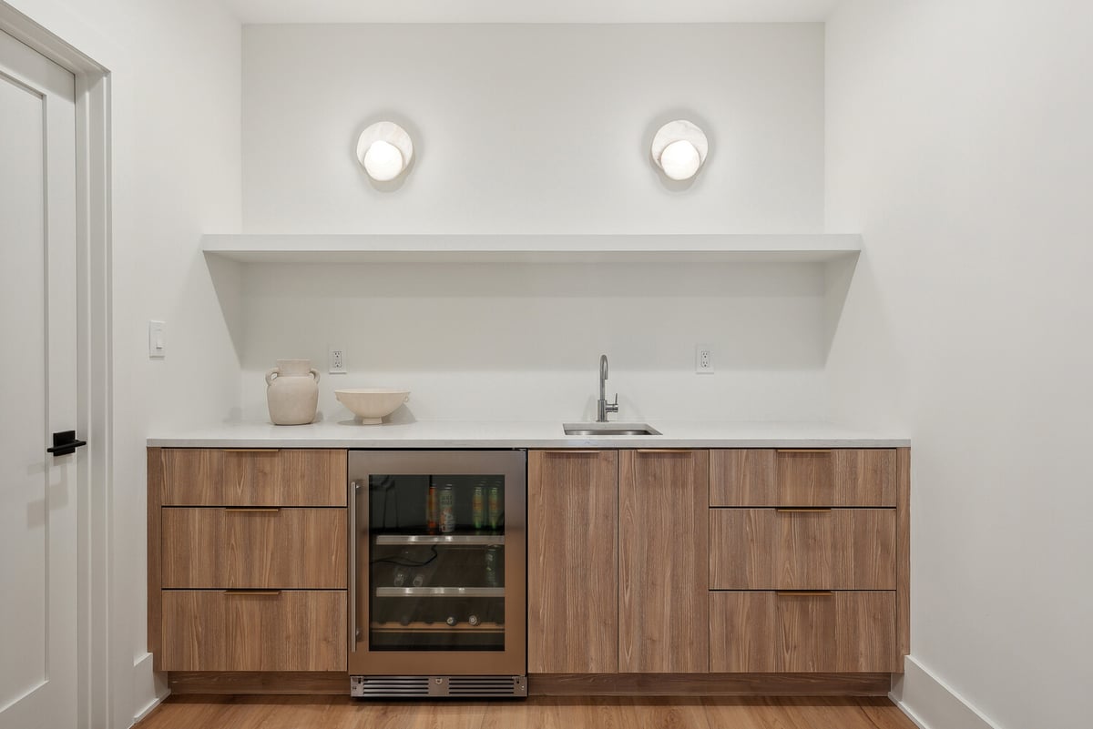 Basement bar and kitchenette with wood cabinetry in a custom home by DesignLab in Bethesda, MD