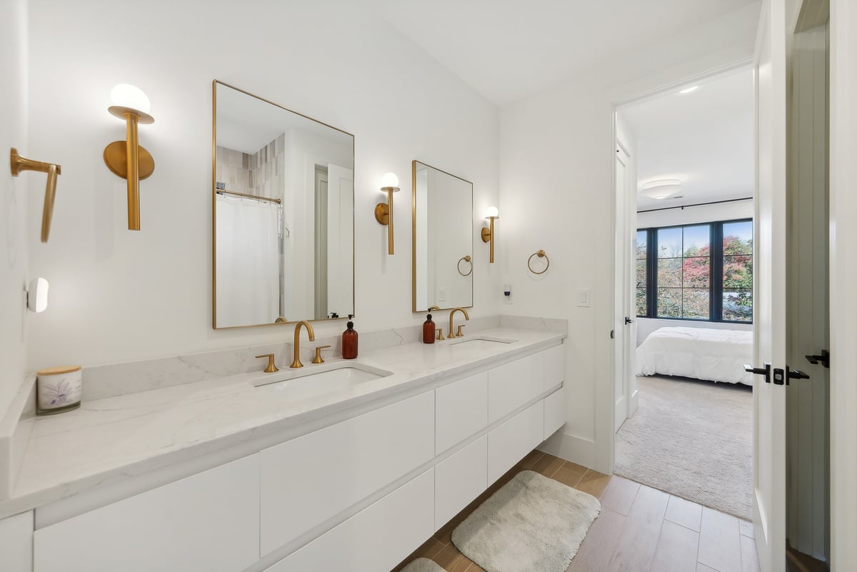 Elegant double vanity bathroom with brass fixtures in a custom home by DesignLab in McLean, VA