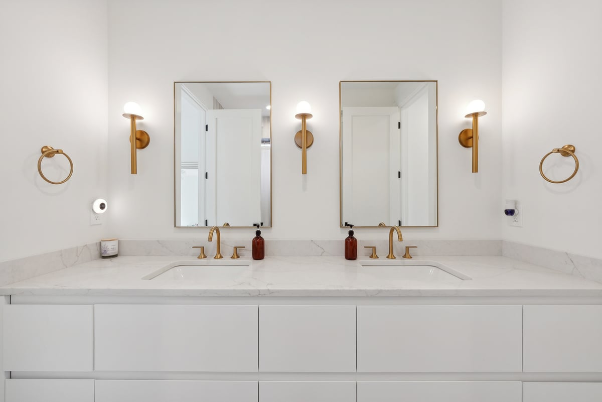 Luxurious bathroom setup with symmetrical mirrors and gold towel rings by DesignLab in Kalorama, DC