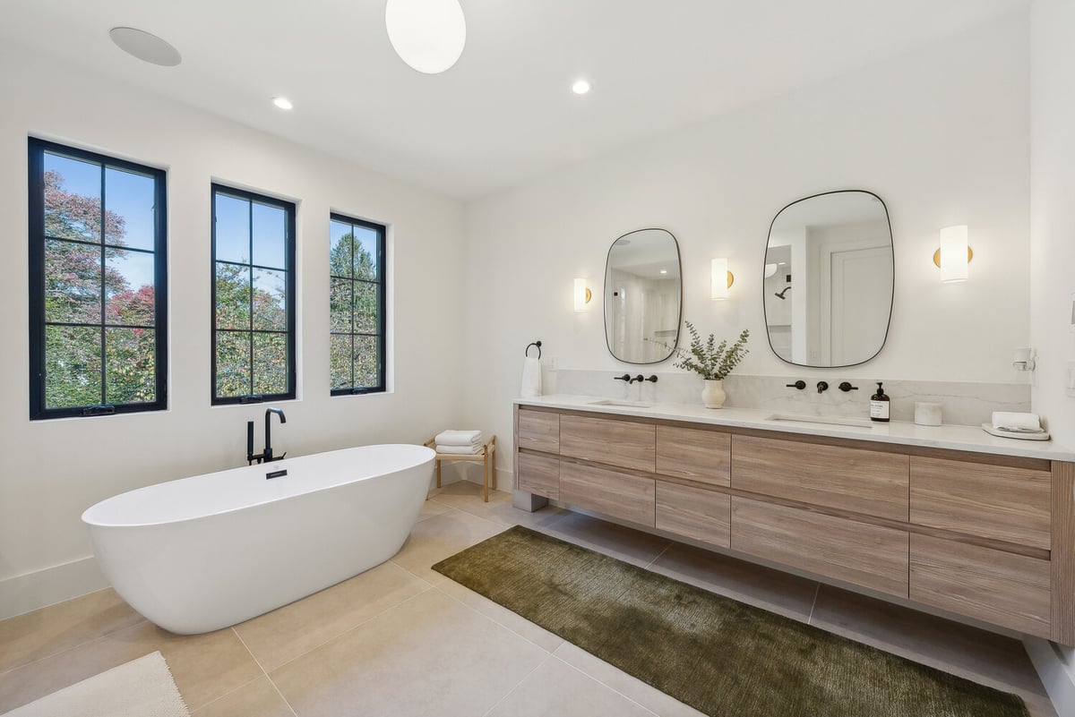 Spa-like bathroom with freestanding tub and wood vanity in a DesignLab custom home in Vienna, VA