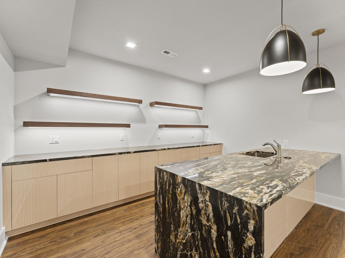 Modern basement wet bar with waterfall stone island by DesignLab in Northern Virginia whole home renovation