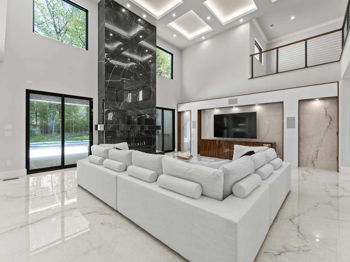 Spacious modern living area with white sectional and fireplace by DesignLab in Northern Virginia