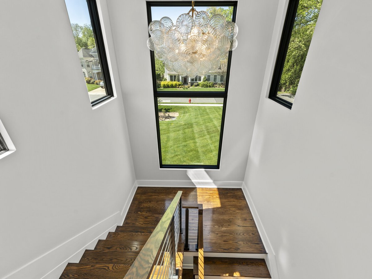 Staircase with floor-to-ceiling windows and chandelier by DesignLab in Northern Virginia home project