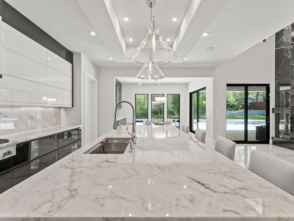 Upscale kitchen and dining space with large marble island in a DesignLab-built custom home in Chevy Chase, MD