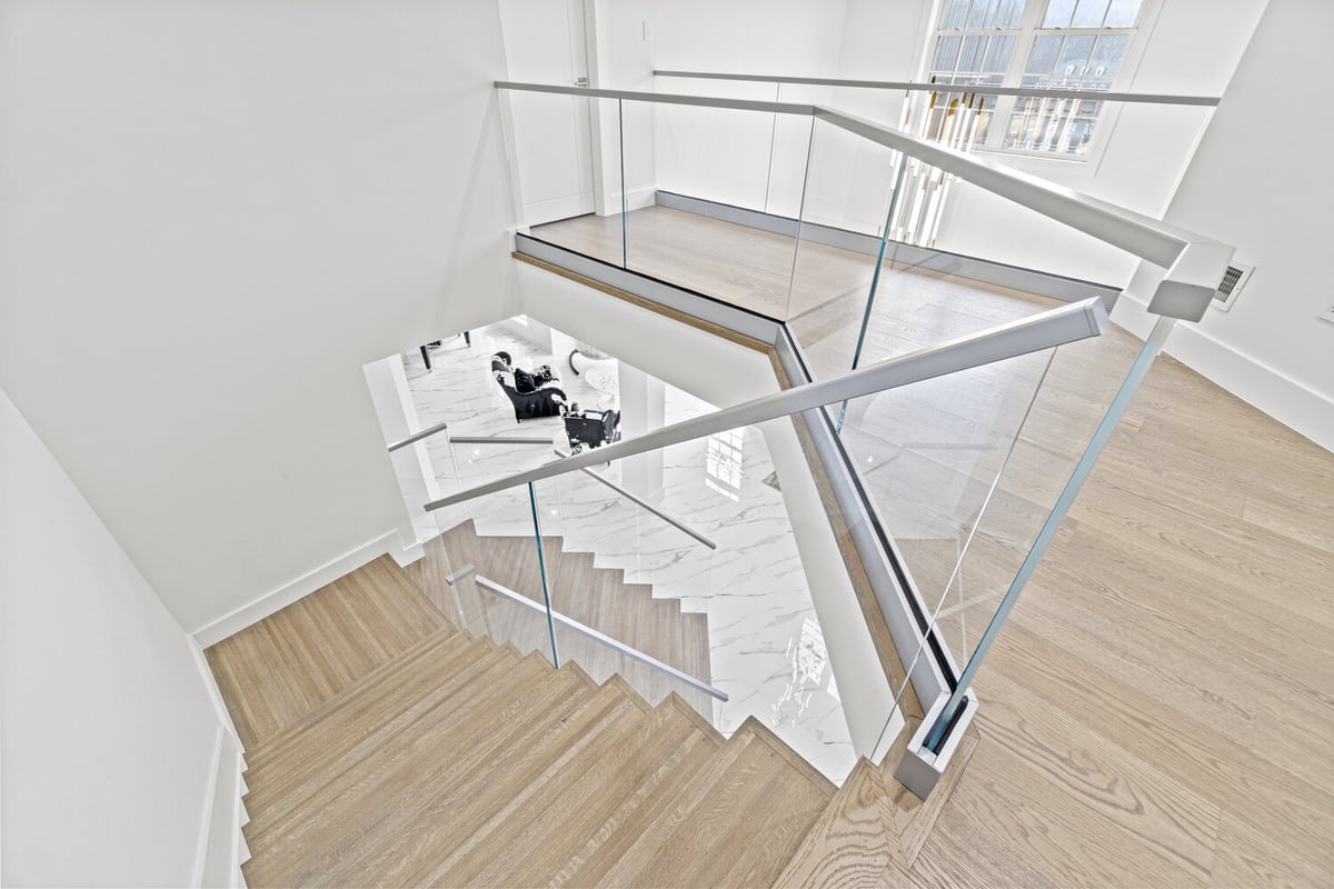 Aerial view of staircase with glass railing and wood treads in designlabs Northern Virginia whole home remodel