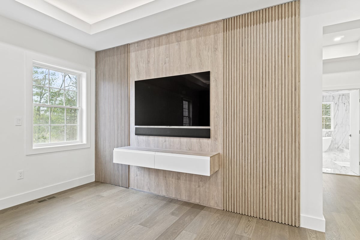 Living room TV feature wall with wood paneling in a custom home by DesignLab in Metro Washington
