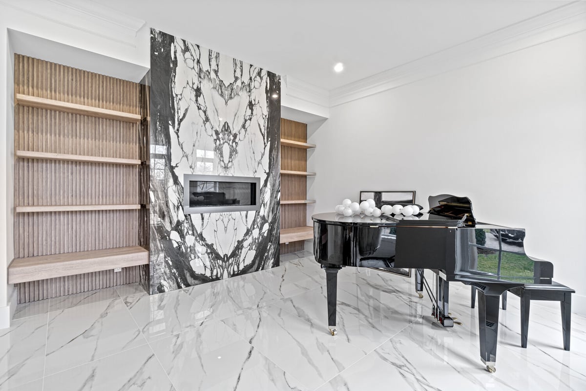 Modern living space with grand piano and book-matched marble fireplace in a whole home remodel by designlab in Northern Virginia