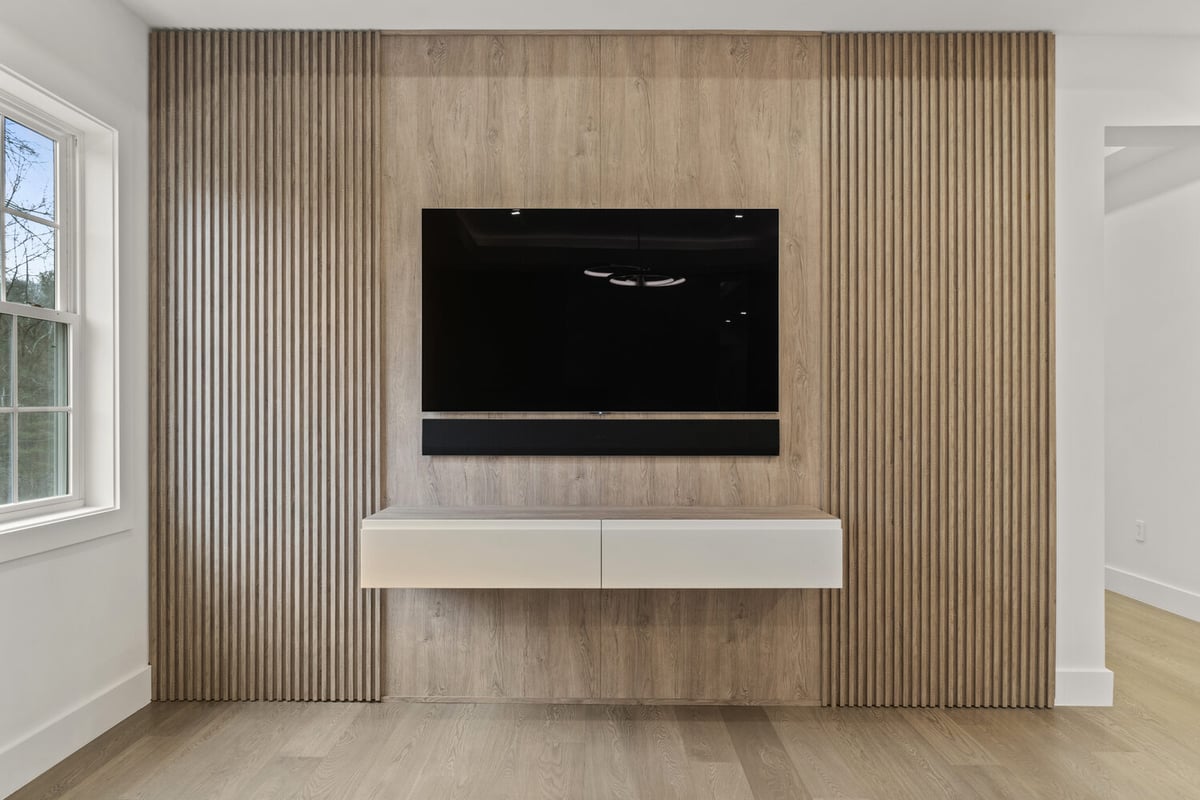 Wall-mounted TV with slatted wood accent feature in bedroom or den by designlab in Northern Virginia