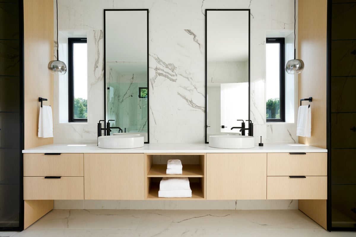 Double vanity with tall mirrors in marble bathroom designed by DesignLab for a Georgetown, DC custom home