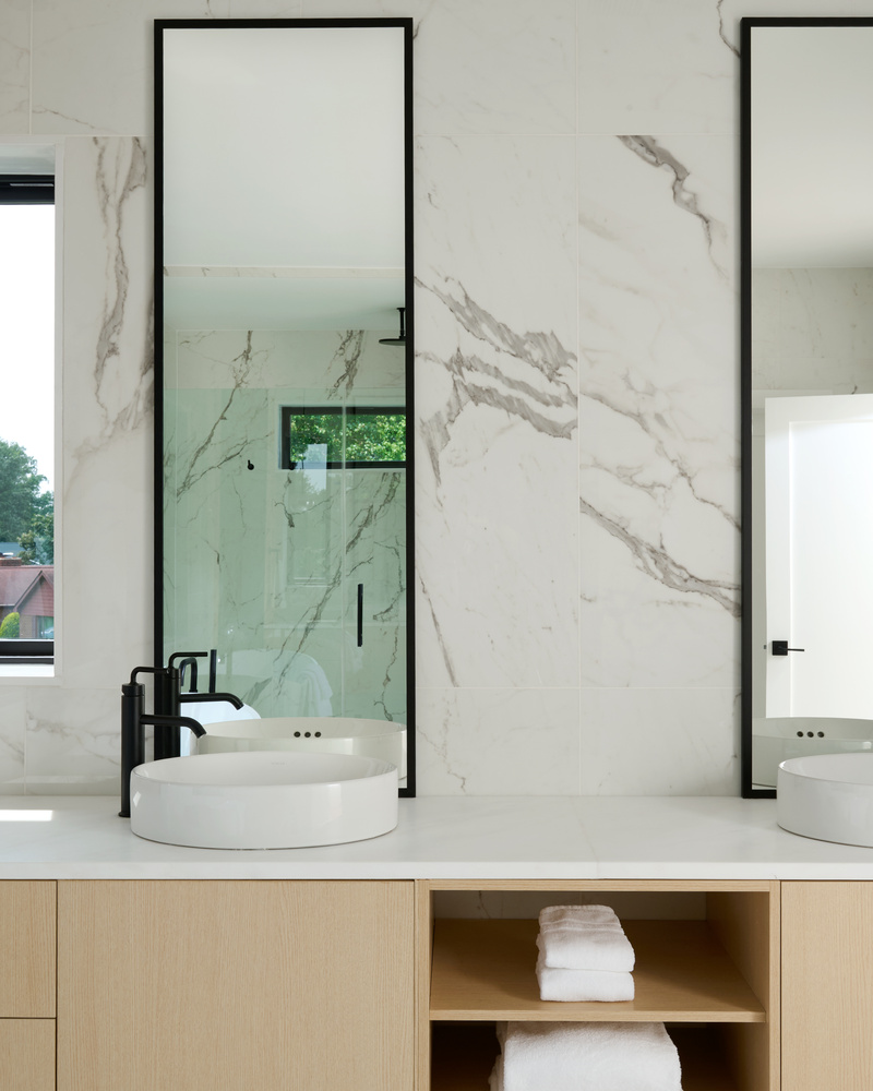 Dual sink vanity with tall mirrors in a modern marble bathroom by DesignLab in Loudoun, VA