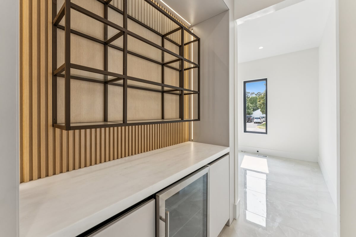 Elegant home bar area with open metal shelving in a custom home by DesignLab in Kalorama