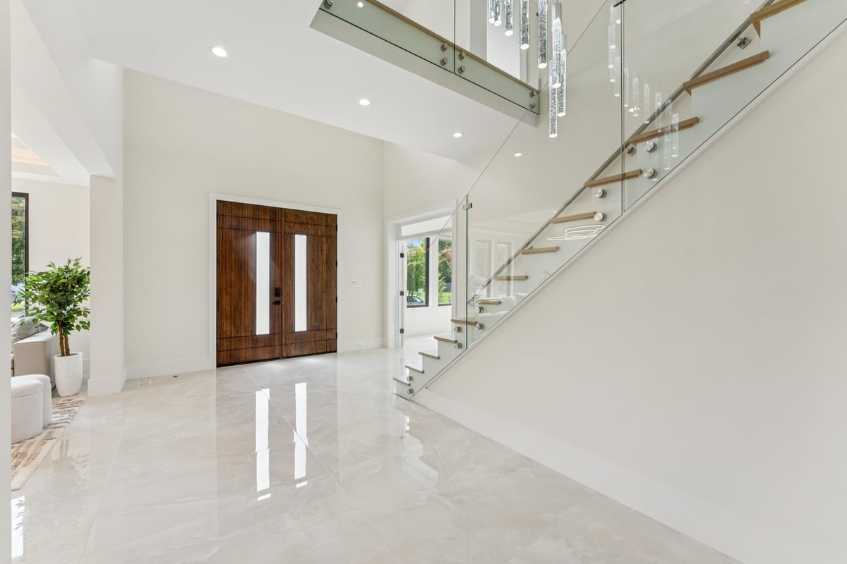 Elegant open foyer with glass staircase in a custom home by DesignLab in McLean