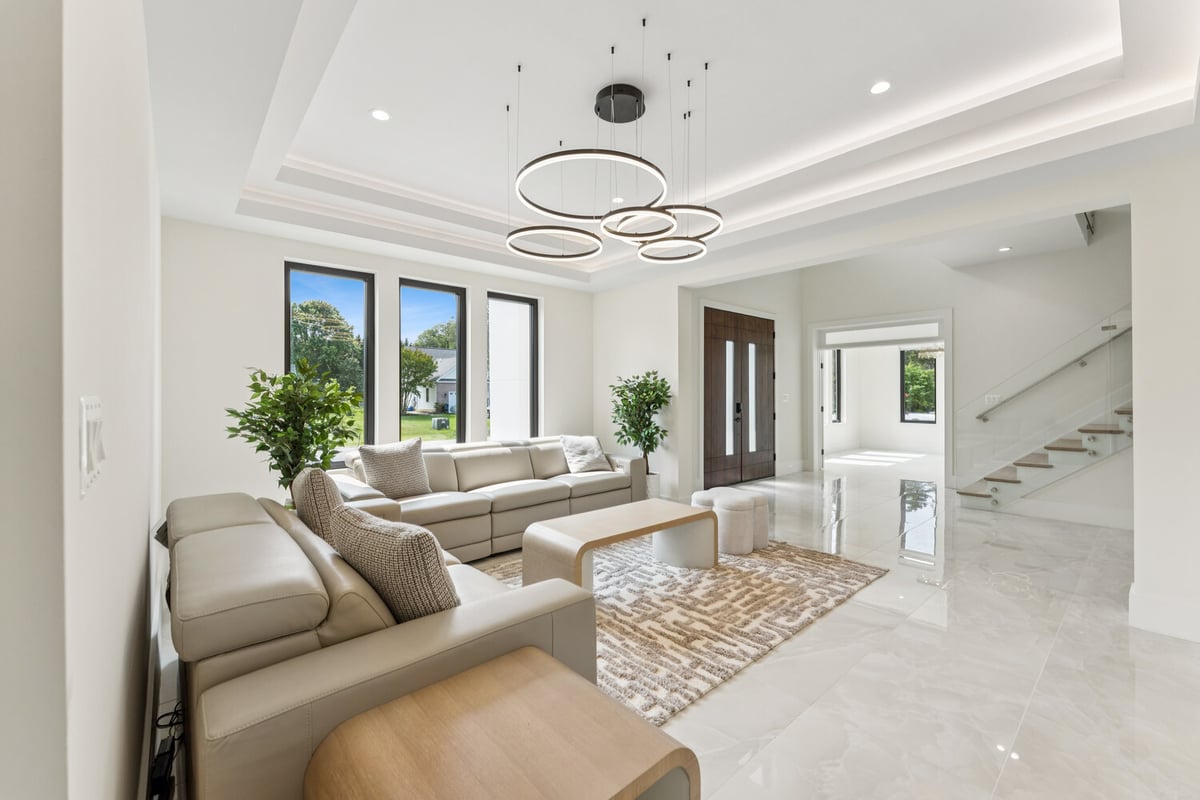 Elegant open living room and foyer with modern chandelier by DesignLab in McLean