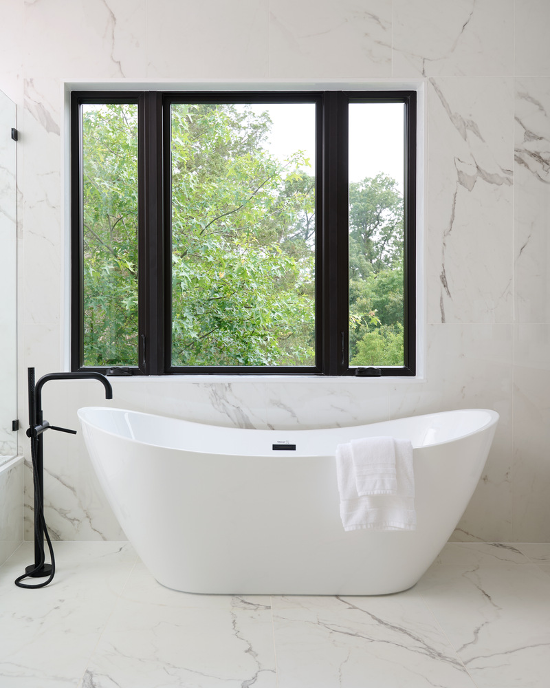 Freestanding soaking tub in a marble bathroom designed by DesignLab for a custom home in Potomac, MD