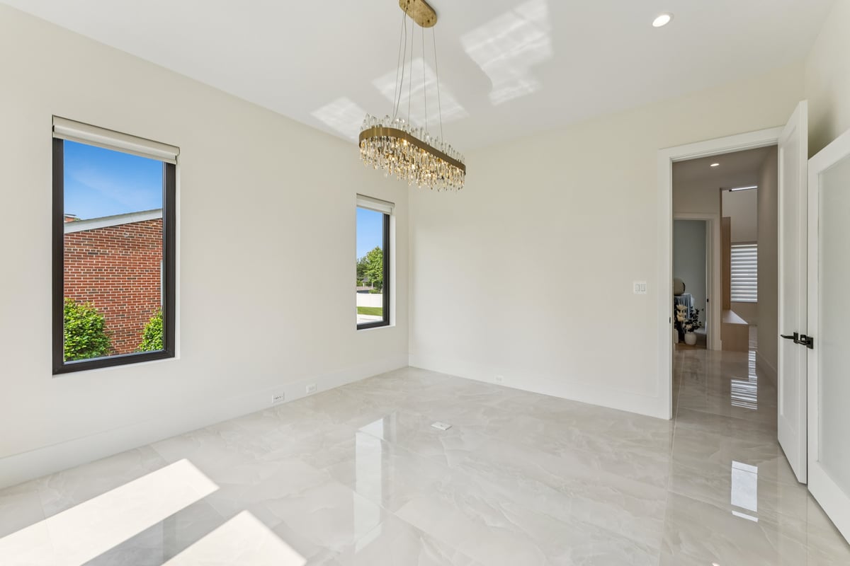 Minimalist bright corner room with chandelier in a custom home by DesignLab in Georgetown