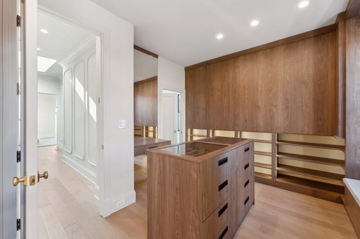Elegant walk-in closet with full-height cabinetry and glass-top island by DesignLab in Capitol Hill, DC