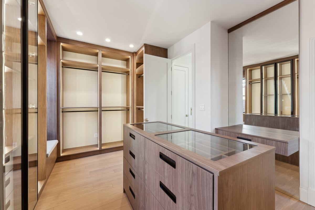 Expansive walk-in closet with built-in vanity and island drawers by DesignLab in Falls Church, VA