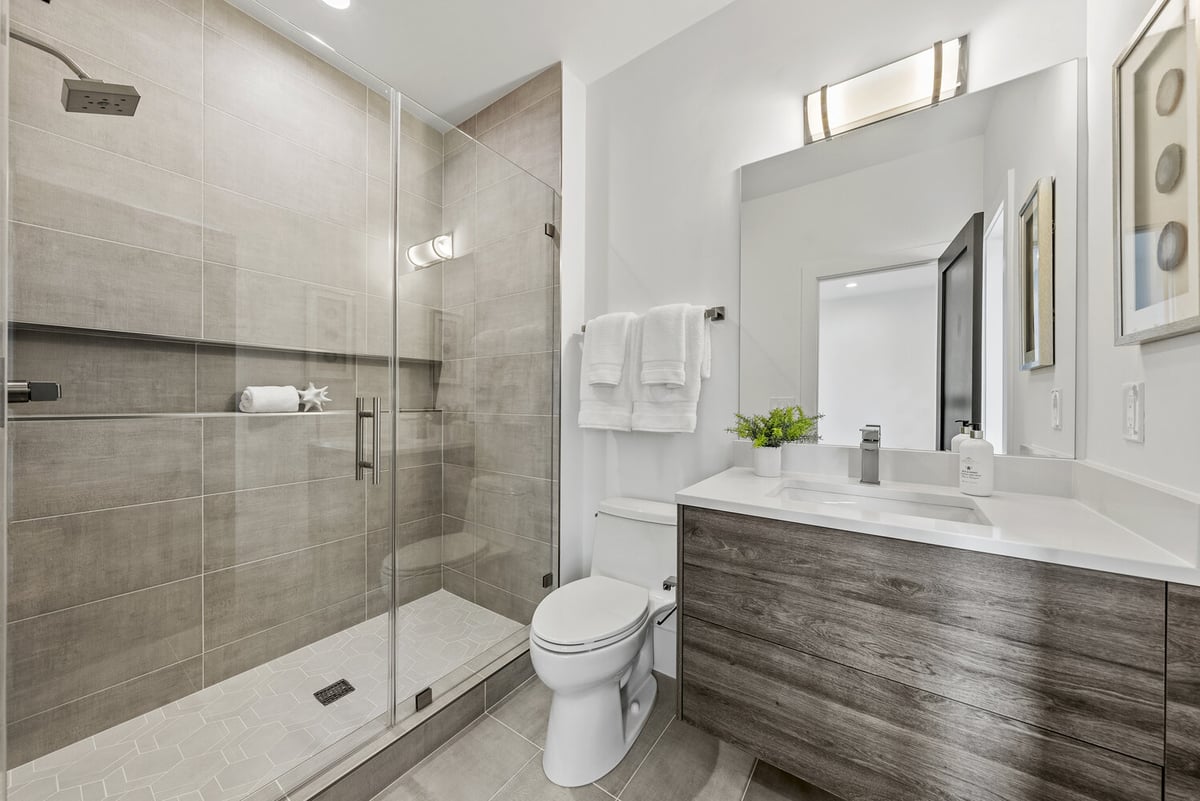 Compact bathroom remodel in River Oaks by DesignLab featuring modern wood vanity and glass shower