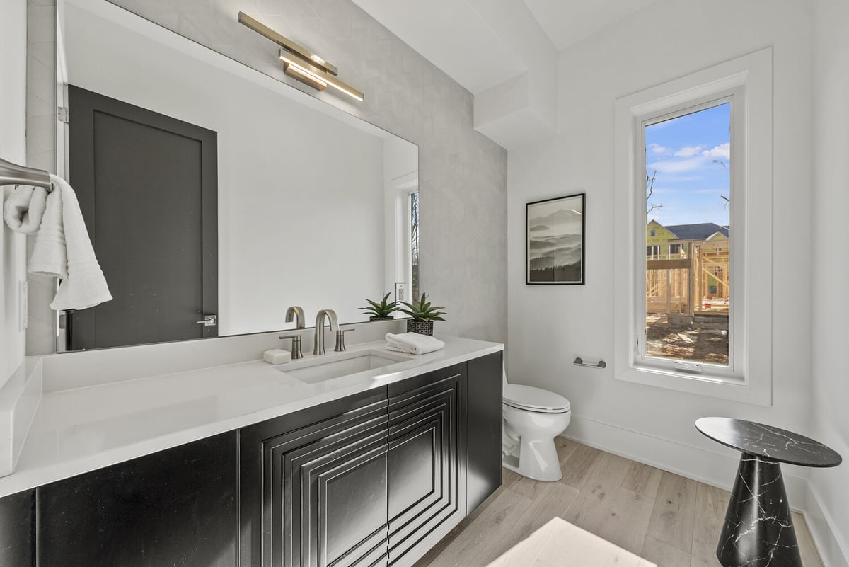 Modern powder bathroom with black vanity and window view in River Oaks whole home by DesignLab