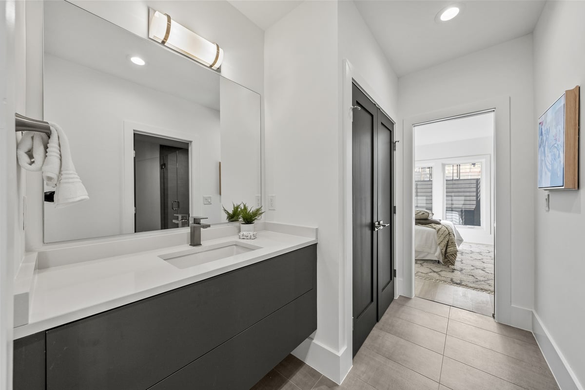 Sleek bathroom vanity with large mirror in a DesignLab custom home in Loudoun, VA