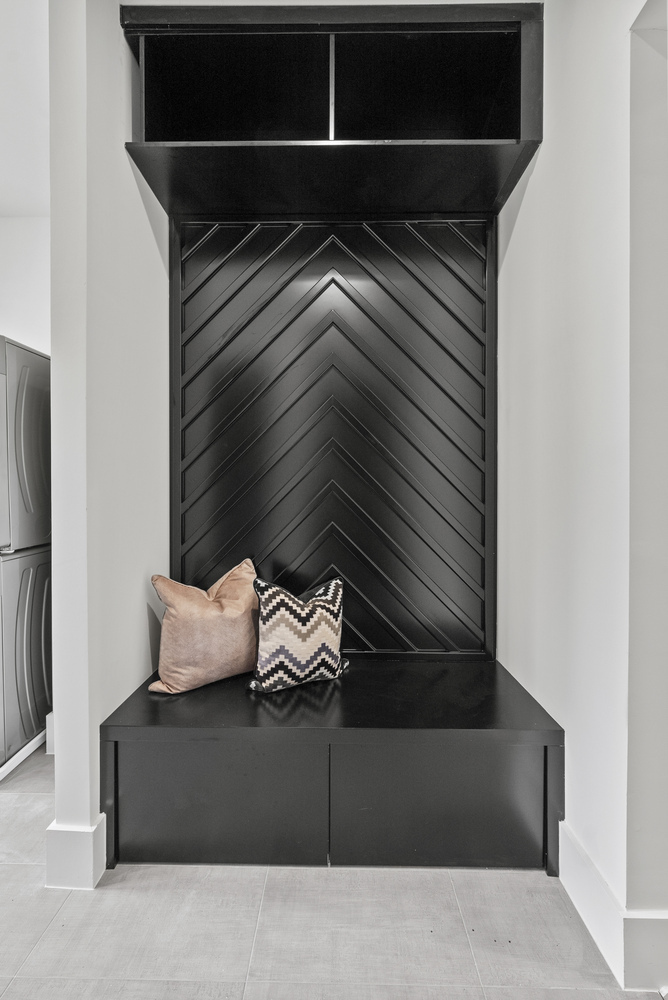 Stylish black chevron mudroom bench with pillows in River Oaks whole home by DesignLab