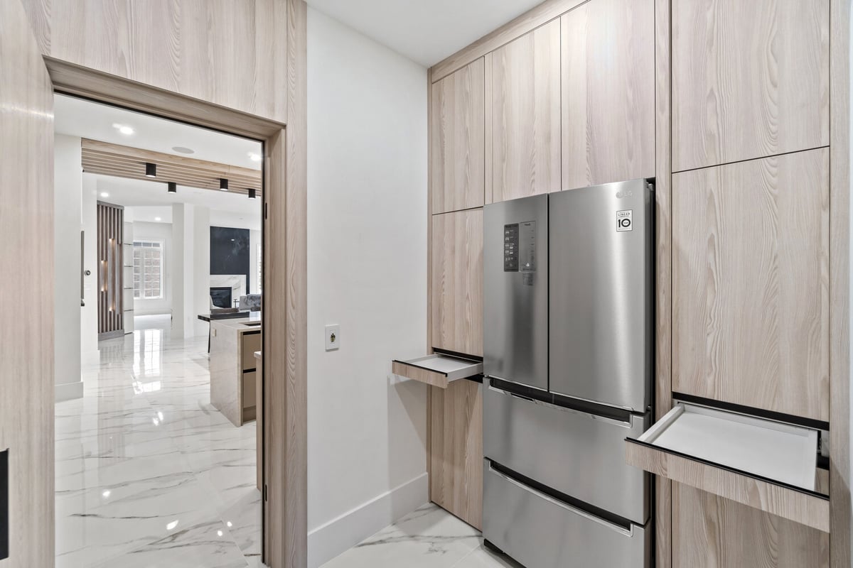 Modern kitchen with hidden pull-out trays beside the fridge in a DC-area custom home by DesignLab